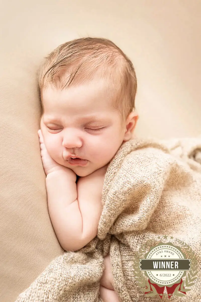 Een baby geposeerd tijdens een geposeerde newbornsessie in de studio