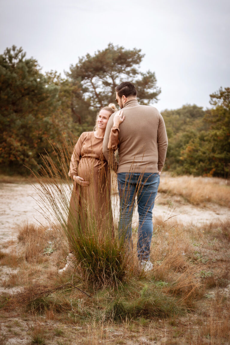 Liefdevol stel tijdens een zwangerschapshoot bij het cadettenkamp tijdens de herfsttijd