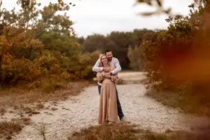 Liefdevol stel tijdens een zwangerschapshoot bij het cadettenkamp tijdens de herfsttijd
