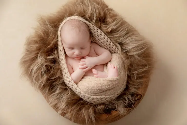 Een baby geposeerd tijdens een geposeerde newbornsessie in de studio