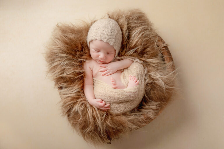 Een baby geposeerd tijdens een geposeerde newbornsessie in de studio/portfolio