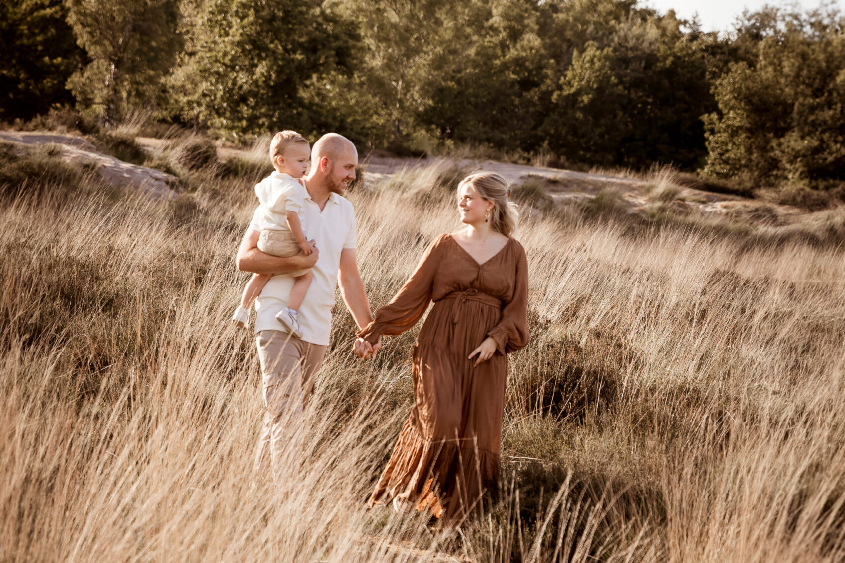 gezin lopend in het hoge gras tijdens een geinshoot op locatie.