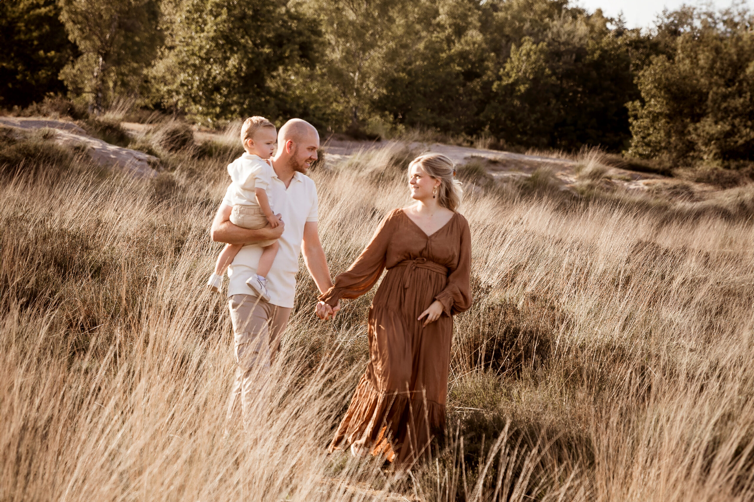 gezin lopend in het hoge gras tijdens een geinshoot op locatie.