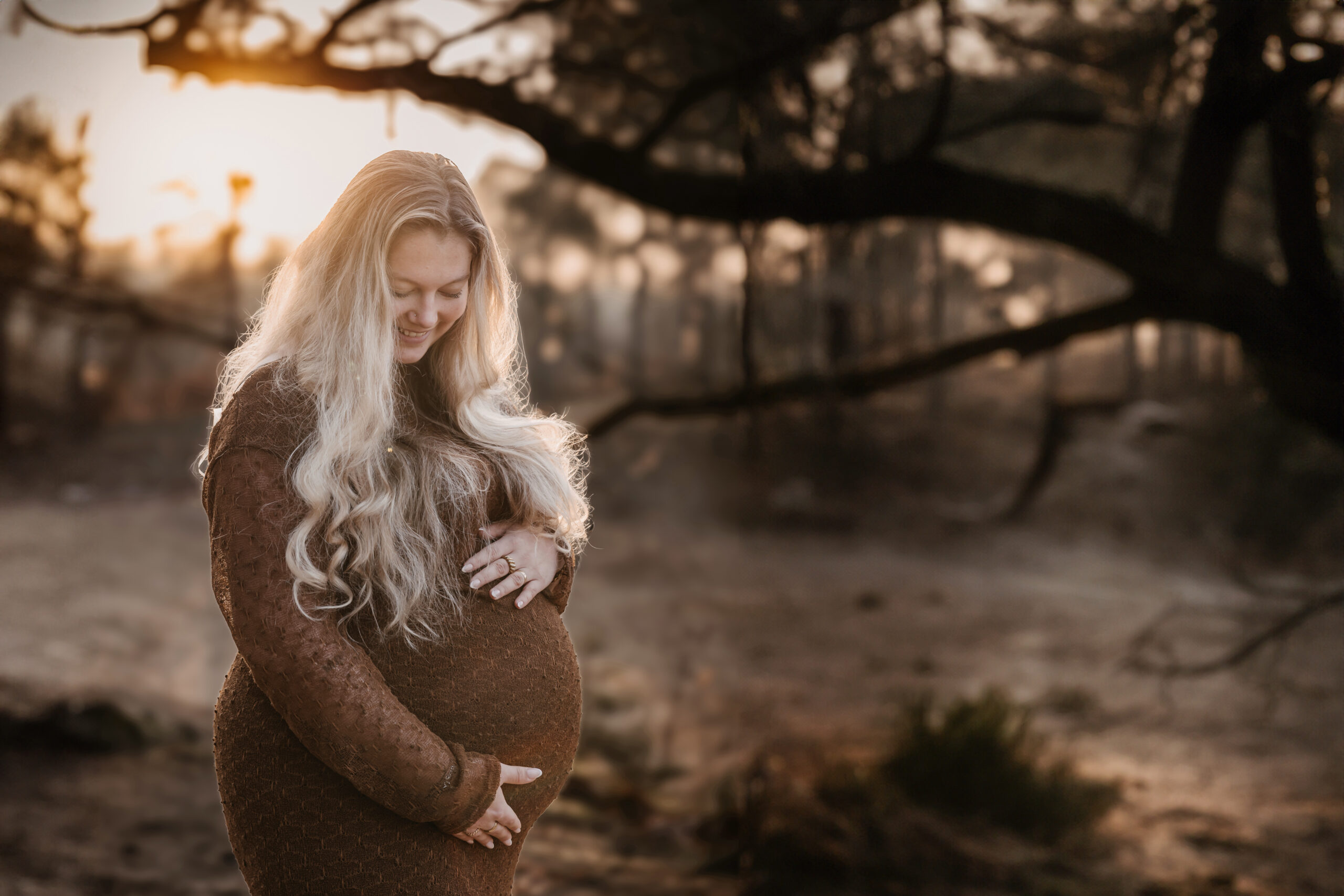 zwangere vrouw tijdens een golden hour fotoshoot op locatie