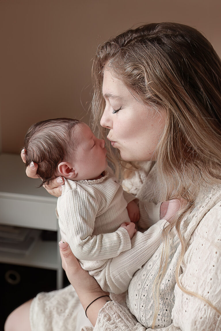 Moeder met pasgeboren baby tijdens newborn lifestyle fotoshoot aan huis