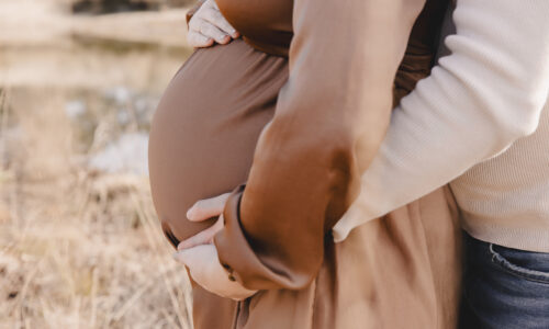 Detailfoto van een zwangere buik tijdens een zwangerschapshoot